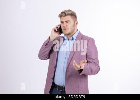 Stylish man in pink blazer talking on mobile phone in studio Stock Photo