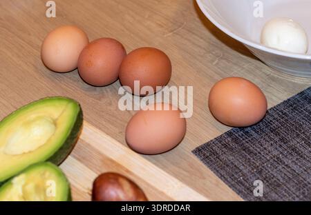 Close up shot of the brown eggs on the wooden kitchen table Stock Photo