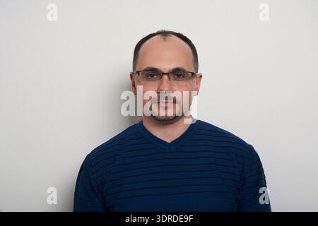 Man Poses for a Collage of Different Looks Against a Plain Background in a Studio Setting Stock Photo