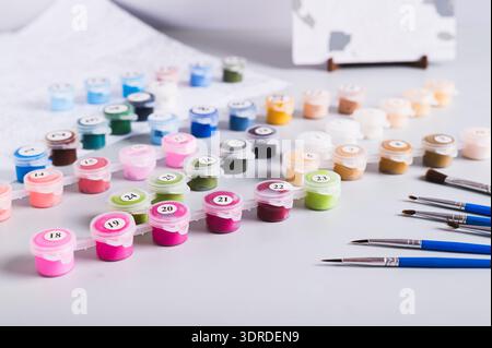 Painting by numbers kit, paints, brushes and paper on table Stock Photo