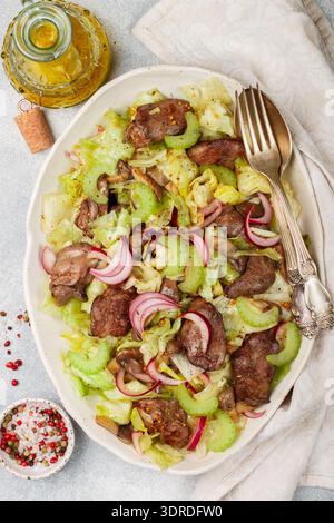 Warm salad of chicken (duck, goose, rabbit) liver, iceberg lettuce, red onion, celery and fried mush Stock Photo
