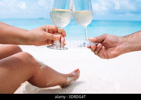 Close-up of a male and a female hands holding two glasses with white wine Stock Photo