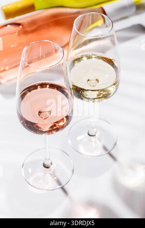 Two wine glasses filled with rose and white wine Stock Photo