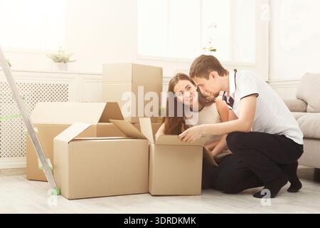 Couple Unpacks Moving Boxes in Their New Home During a Bright Afternoon Stock Photo