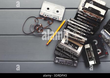 Collection of Old Audio Cassettes Arranged on a Table Next to a Pencil and Tape Stock Photo