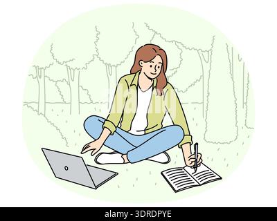 Woman student is sitting on lawn making notes in notebook and using laptop enjoying working in park Stock Photo