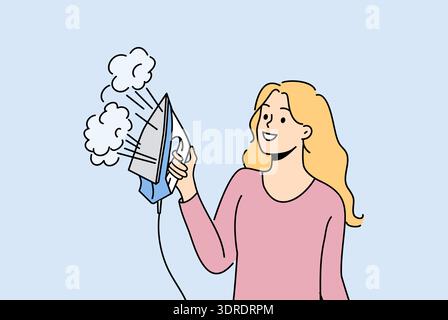 Woman housewife holds iron with steam function and smiles enjoying doing housework Stock Photo