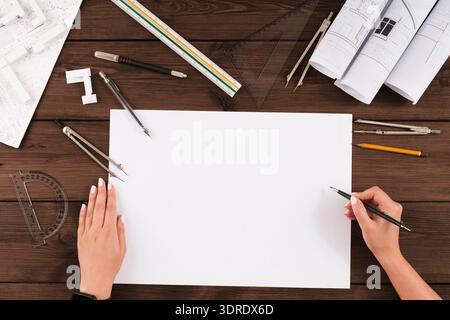 Collection of Tools and Materials for Architectural Drawing and Planning on a Wooden Table Stock Photo