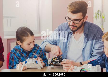Students Learn to Build Robots With Guidance in a Classroom Setting During Afternoon Session Stock Photo