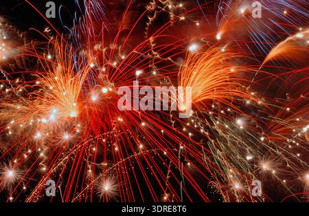 Long exposure of high-altitude fireworks with explosions Stock Photo