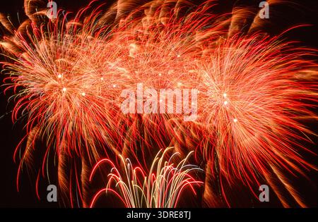 A colorful firework display in the night sky with rockets Stock Photo