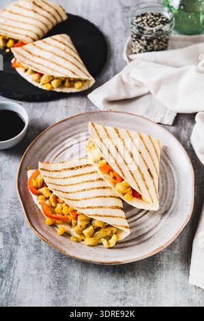 Chicken quesadilla with corn and peppers wrapped in tortilla on a plate vertical view Stock Photo