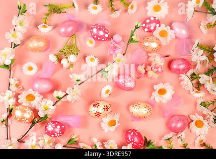 Abstract spring easter composition with gold and pink painted eggs, feathers, flowering branches and flowers. Happy easter conce Stock Photo