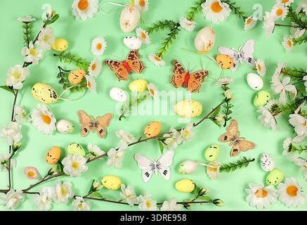 Abstract spring easter composition with painted eggs, feathers, butterflies, flowering branches and flowers. Happy easter concep Stock Photo