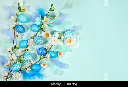 Happy Easter concept. Abstract spring Easter composition with blue painted eggs, feathers, butterflies, flowering branches and f Stock Photo