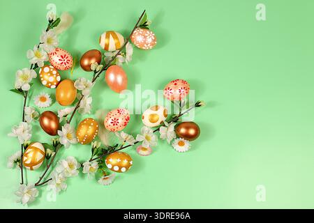 Happy Easter concept. Abstract spring Easter composition with golden painted eggs, feathers, butterflies, blossom branches and f Stock Photo