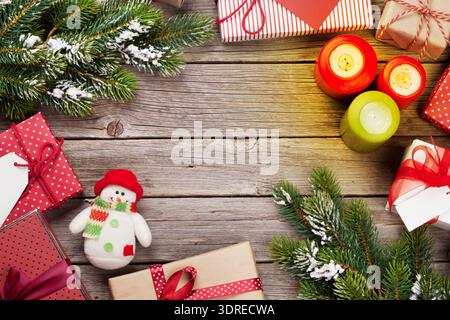 Christmas gift boxes and candles on wooden table Stock Photo