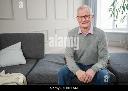 Portrait of confident stylish European middle aged senior man at home. Older mature 70s man smiling. Happy attractive senior gra Stock Photo