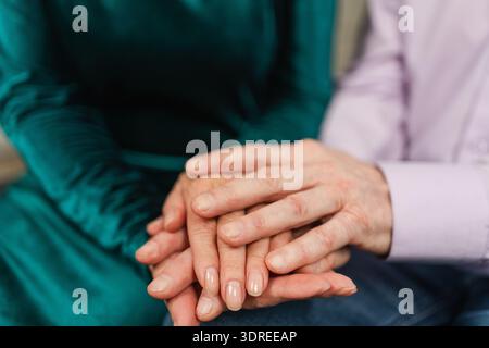 Old couple hands. Senior couple in love holding hands. Mid age old husband wife touching hands with tenderness love enjoying wel Stock Photo