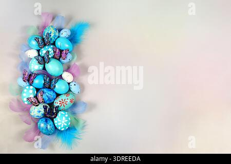 Happy Easter concept. Abstract spring Easter composition with blue painted eggs, feathers, butterflies, flowering branches and f Stock Photo