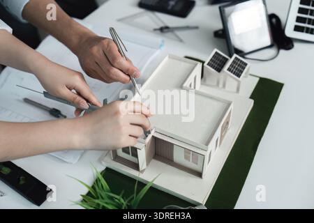 Two people are working on a model of a house Stock Photo