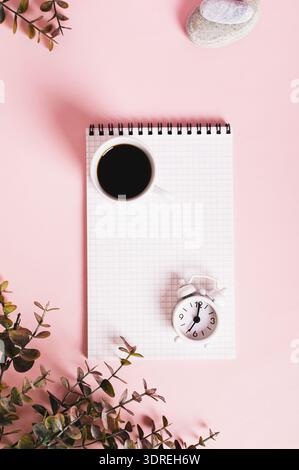 Blank notebook, cup of coffee and alarm clock on pink top view web banner Stock Photo