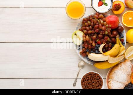 Fresh Fruit and Breakfast Items Arranged in a Colorful Collage on a Wooden Table Stock Photo