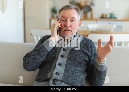 Happy middle aged senior man talking on smartphone with family friends. Older mature grandfather with cell phone talking with gr Stock Photo