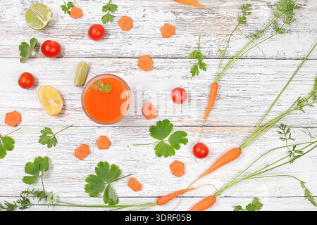Detox drink in a glass goblet, carrot and parsley slices on a wooden background. Fresh natural carrot smoothie or juice, weight Stock Photo