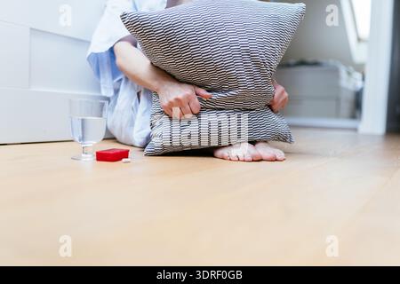 Close up of antidepressants and glass of water on bedroom floor Stock Photo