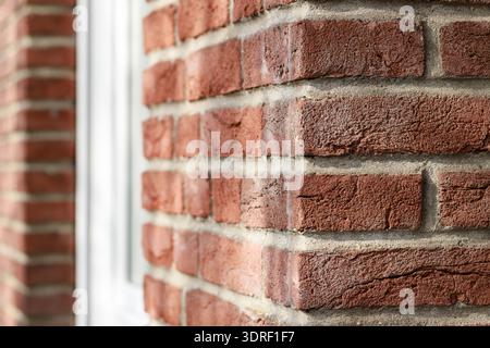 Old red brown brick wall with diminishing perspective. Detail of brick house in sunny day. Stock Photo