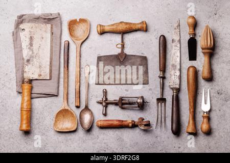 A collection of various retro kitchen and cooking utensils displayed on a table Stock Photo