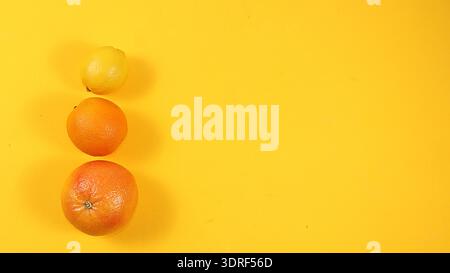 Summer banner, citrus fruits, grapefruit, orange, lemon on a bright yellow background, minimal concept of relaxation and detox, Stock Photo