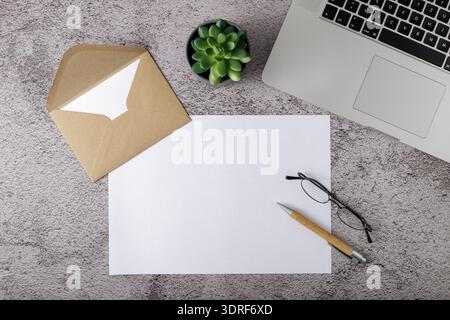 Workplace with blank paper, wooden pen and laptop on stone background. Home or in the office Stock Photo