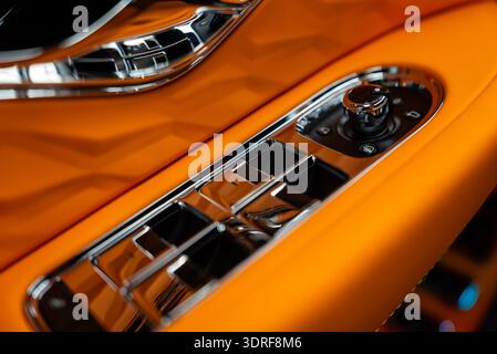 Driver door switch panel with chrome toggles in orange leather Stock Photo