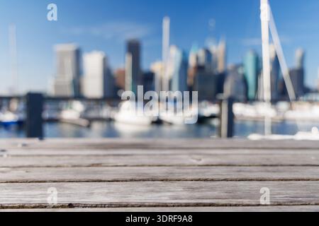 An empty wooden barbecue table set outdoors with a blurred view of the iconic Manhattan skyline Stock Photo