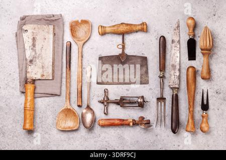 A collection of various retro kitchen and cooking utensils displayed on a table Stock Photo