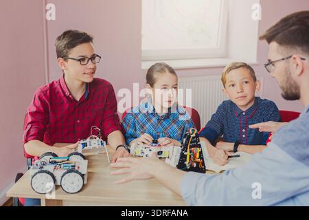Students Learn About Robotics and Programming in a Classroom Setting Stock Photo