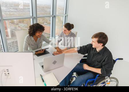 Stack of hands. Business startup teamwork unity concept. Top view of diverse multiracial business people putting hands together. Stock Photo