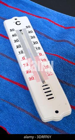 white thermometer in celsius isolated on blue bath towel Stock Photo
