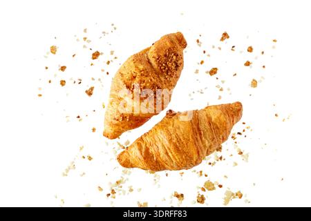 Fresh baked butter and almond nut breakfast croissants  with crumbs flying isolated on white background Stock Photo