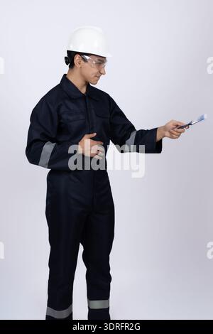 Technician in blue overalls holding a clipboard Stock Photo