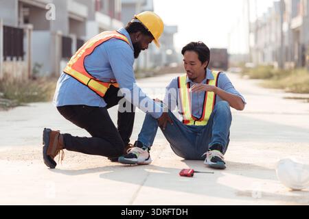 Coworkers provided first aid to a worker who had an accident on his leg Stock Photo