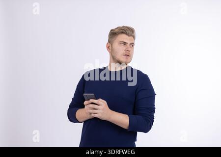 Young man in blue shirt drinking from a cup Stock Photo