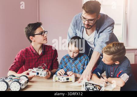 Students Learn About Robotics With Teacher in Classroom During Afternoon Session Stock Photo