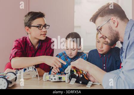 Kids Learn About Robotics With Teacher During Workshop in Classroom in the Afternoon Stock Photo