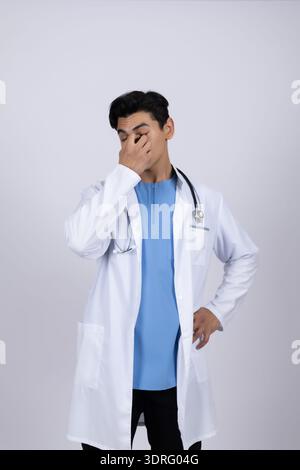 Medical professional in white coat looking thoughtful Stock Photo