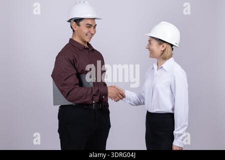 Construction workers shaking hands in a studio Stock Photo