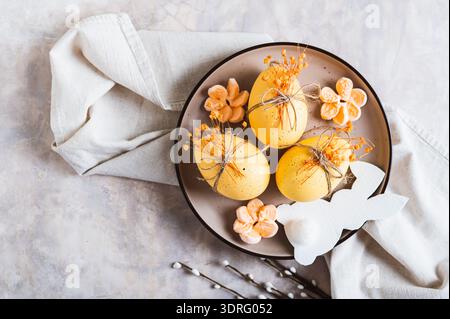 Close up of Easter decorations, decorated eggs and bunny on a plate on the table top view Stock Photo