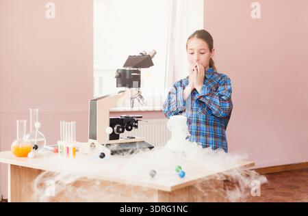 Child Conducts Science Experiment Using Microscope With Fog in a Classroom Setting Stock Photo